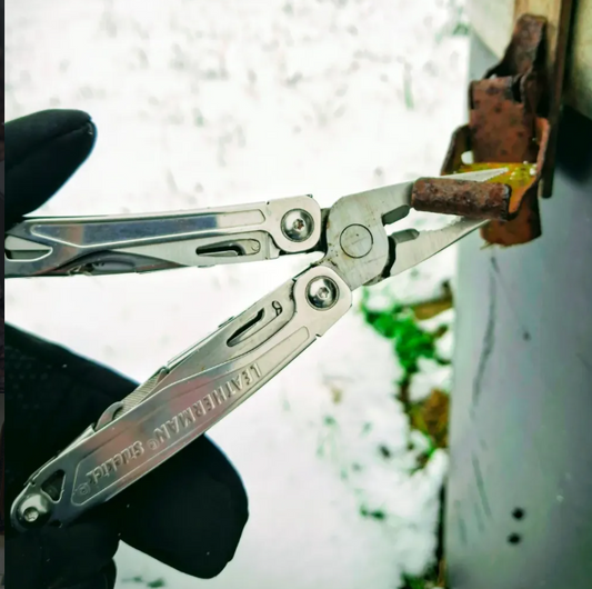 leatherman sidekick multitool die aan een roestig voorwerp werkt